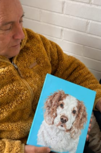 Hombre sosteniendo el cuadro de su perrito