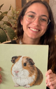 Mujer joven sosteniendo el cuadro de su mascota hámster